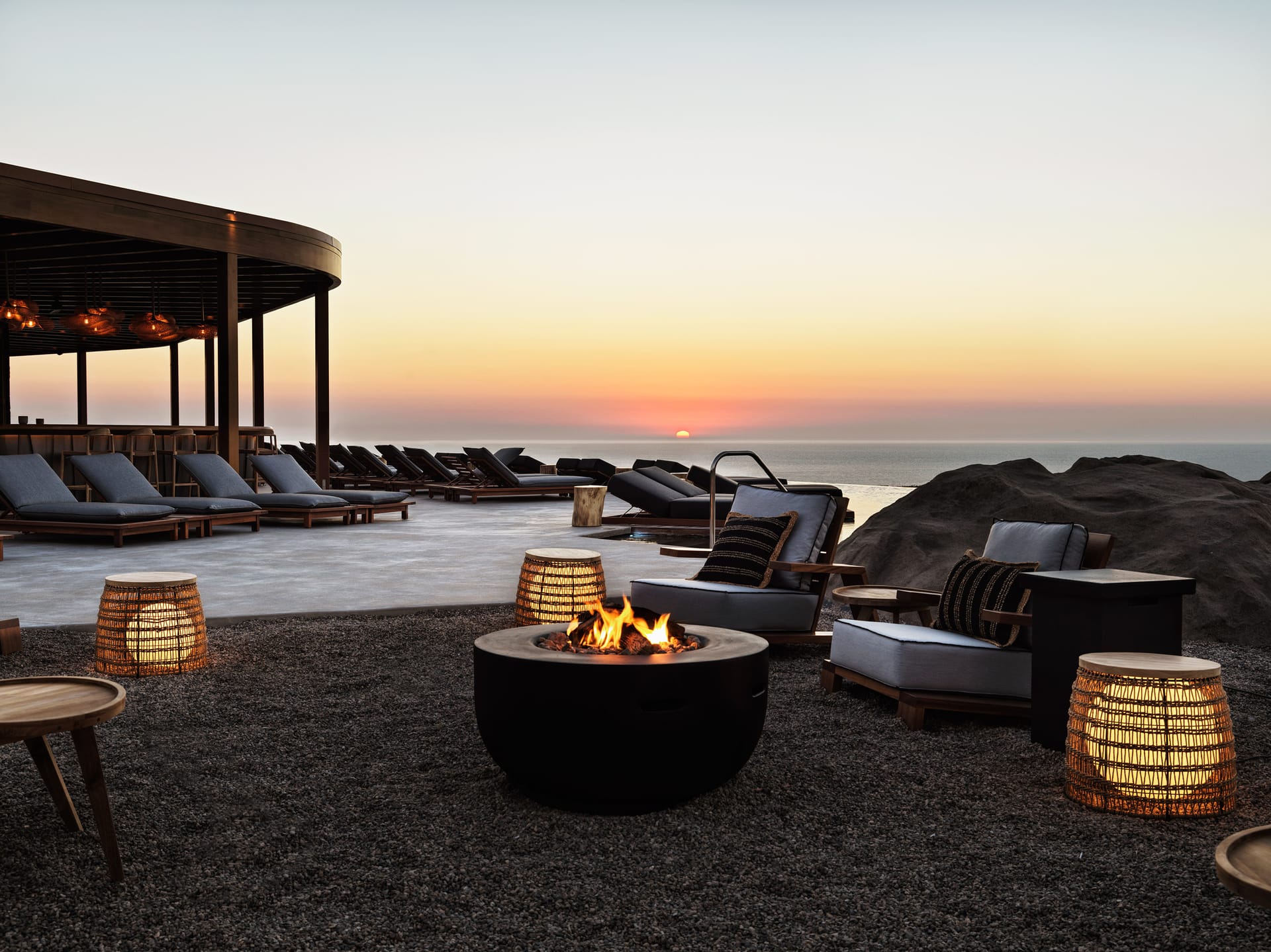 Indulge in tempting snacks and drinks amidst a carefree vibe, where every sip and bite are moments of pure healing. Unwind with the breeze of the Aegean Sea under the Greek sun or join Aperitivo Time by the igniting Fire Pit of Bar on The Rocks.